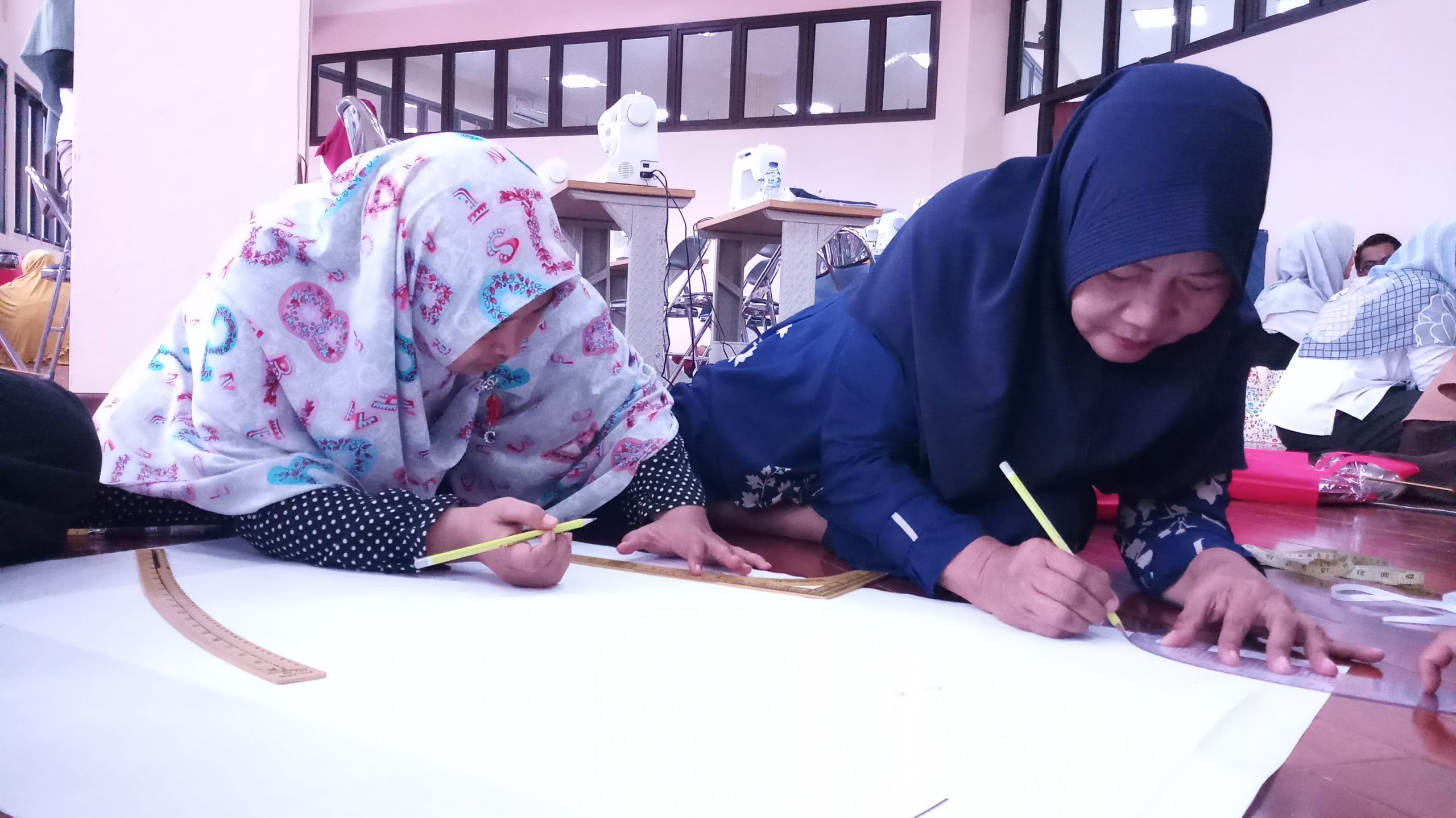 Ibu-ibu RW 11, Kelurahan Warakas, Kecamatan Tanjung Priok, sedang menggambar pola dalam pelatihan menjahit sebagai bagian dari program CSR UPP PJBB 2 PLN UIP JBB di Tempat Kumpul Kreatif Pasar Permai, Koja, Jakarta Utara, pada Senin (29/4/2019). (Foto: beritabatam.co/Hamdi Putra)