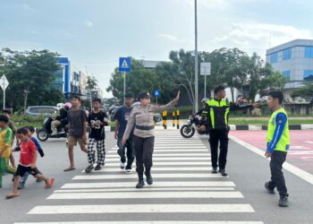 Personel Polwan Polsek Batam Kota, Polresta Barelang, turun langsung mengatur lalu lintas di depan SD Negeri 001 Sungai Panas, Sabtu 13 Juni 2026
Foto: Polresta Barelang