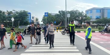 Personel Polwan Polsek Batam Kota, Polresta Barelang, turun langsung mengatur lalu lintas di depan SD Negeri 001 Sungai Panas, Sabtu 13 Juni 2026
Foto: Polresta Barelang